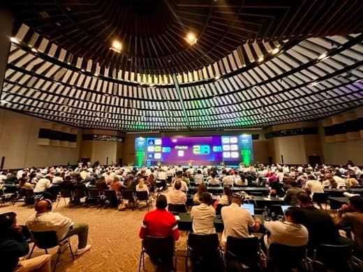 The domed main hall of the Cartagena de Indias Convention Center seen from the back rows, a full audience facing the stage